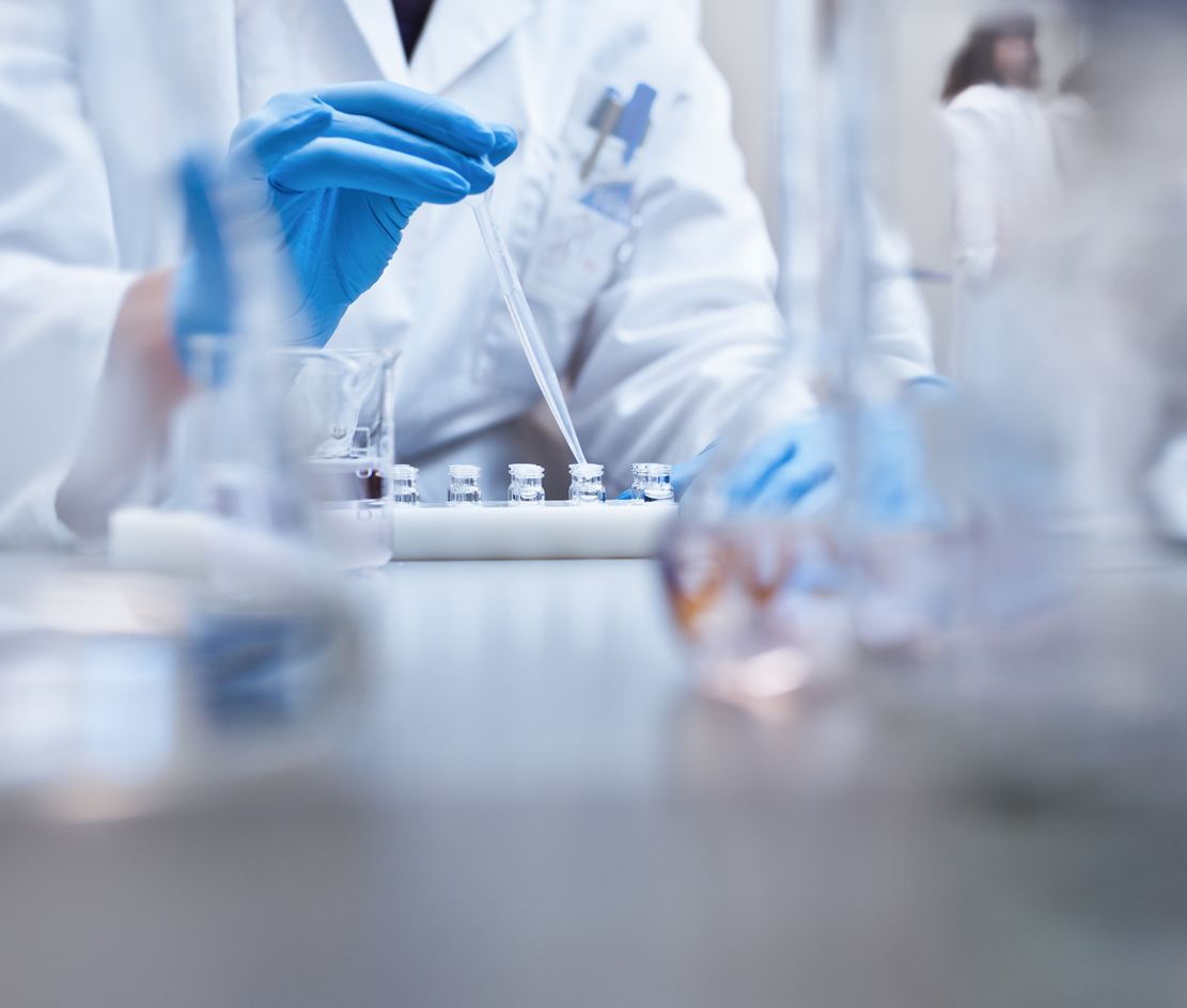 Chemist filling vials in experiment at laboratory
