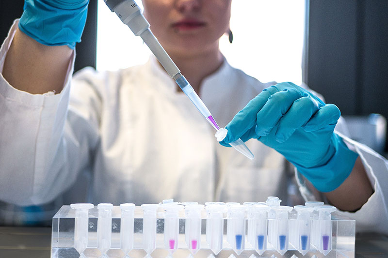 Woman-in-GMP-lab-inserts-liquid-into-test-tube-vial