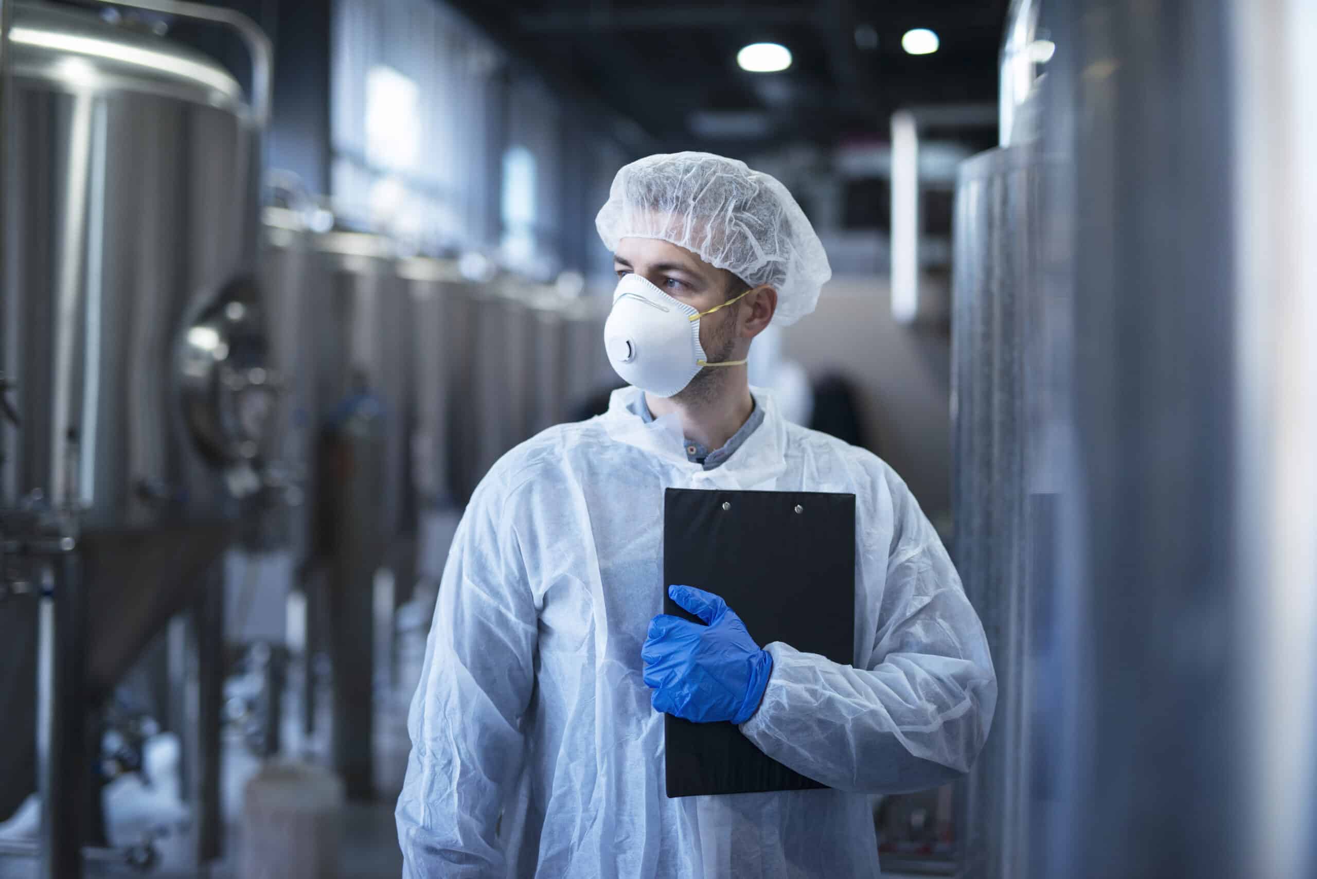 man-in-lab-coat-and-mask-conducts-GMP-audit-in-facility